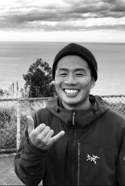 Kentaro Furukawa smiling in a cap in grayscale